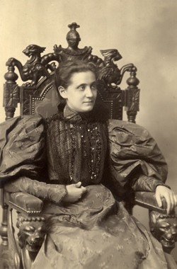 Jane Addams as a young woman, undated studio portrait by Cox, Chicago, seated in an ornate chair and wearing a puffy dress. By User:Example, Attribution, https://commons.wikimedia.org/w/index.php?curid=31106362