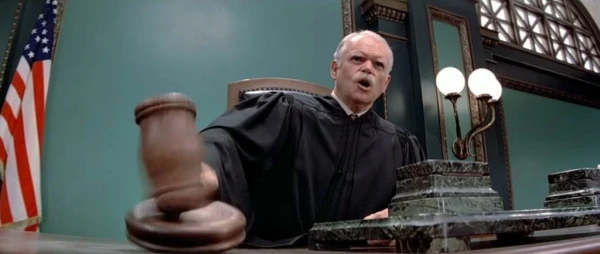 A court room judge banging his gavel and shouting for order