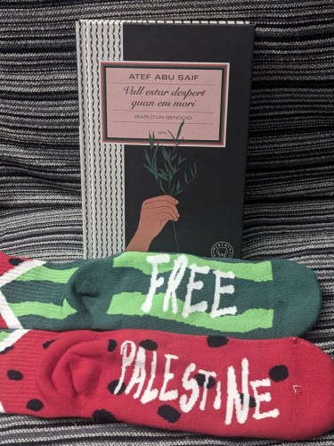 Calcetines de sandía con el lema "Free Palestine", cada calcetín tiene los colores contrarios de la parte interior y exterior de una sandía. Y el libro que ha publicado Blackie Books (la edición en catalán) de Atef Abu Saif  "Vull estar despert quan en mori" sobre el genocidio de Gaza.