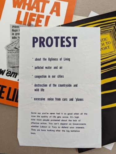 A black and white photograph of a leaflet that has "Protest" as the title, followed by these bullet points: about the Ugliness of Living, polluted water and air, congestion in our cities, destruction of the countryside and wild life, excessive noise from cars and plans. This is followed by this paragraph: "Some say you've never had it so good when all the time the quality of life gets worse. It's high time more people protested about the lack of effective action. You can't depend on Governments whether Labour or Tory to defend your interests. They are busy looking after the big battalion boys"