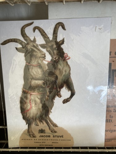 Antique print of two sinister looking goats standing on hind legs, beribboned and cavorting. 