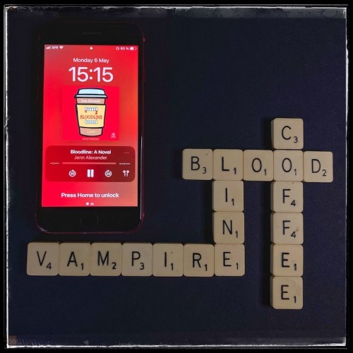 A red iPhone with the cover of Bloodline by Jenn Alexander, narrated by Quinn Riley, on a black background. Next to the phone, Scrabble letters from the words Blood, Line, Vampire, Coffee.
